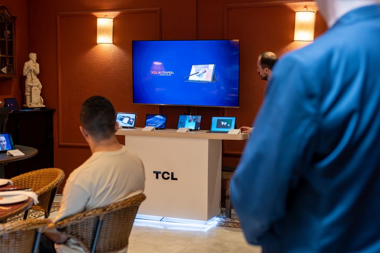 About A professional business presentation showcasing new, sleek tablets and technology in a modern showroom setting.